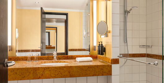 Hotel Remarque 2-Raum-Suite Badezimmer mit Waschbecken, Dusche, Spiegel