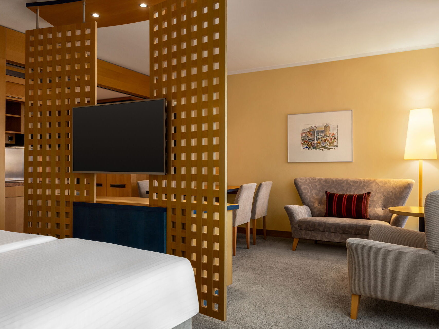 Junior Suite mit Doppelbett, Fernseher, Sofa, Sessel und Stehlampe