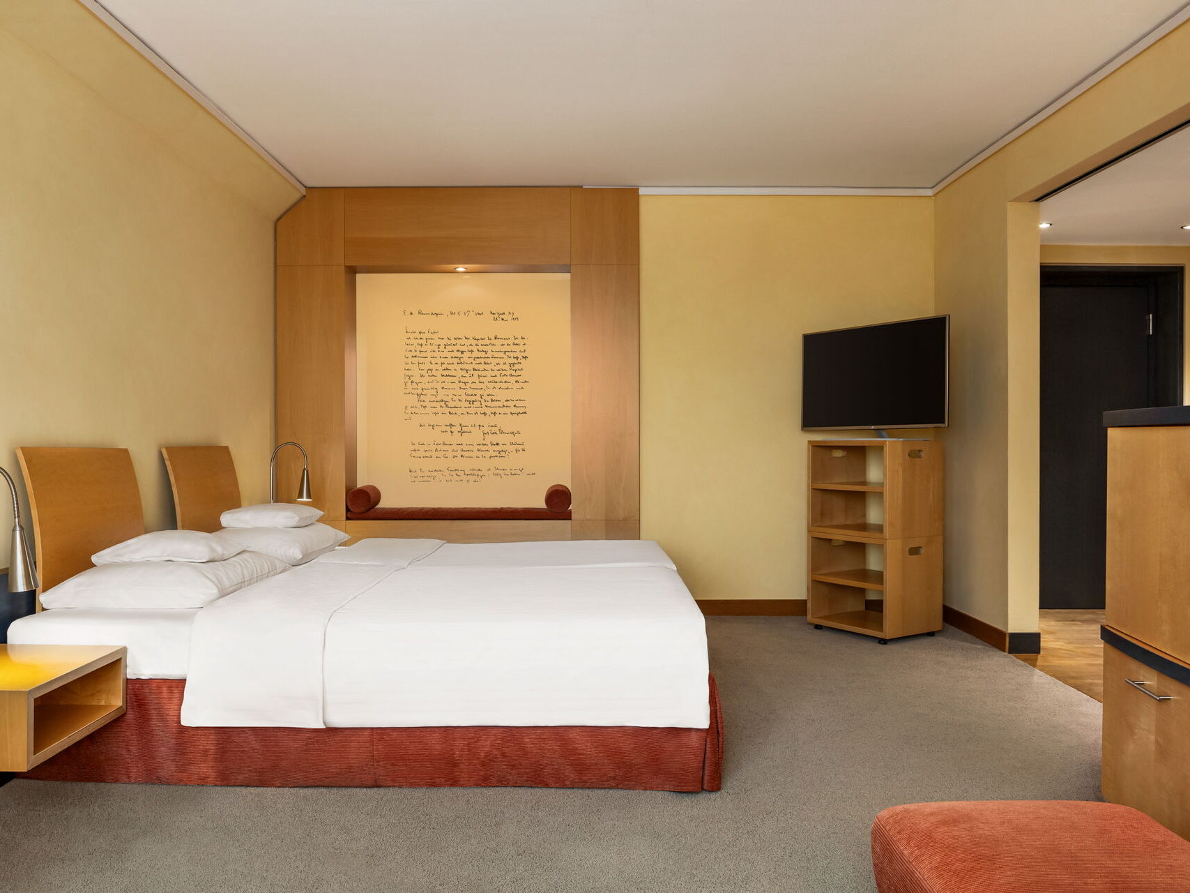 Executive double room with a double bed, dresser, TV, wardrobe, wall art, and hallway