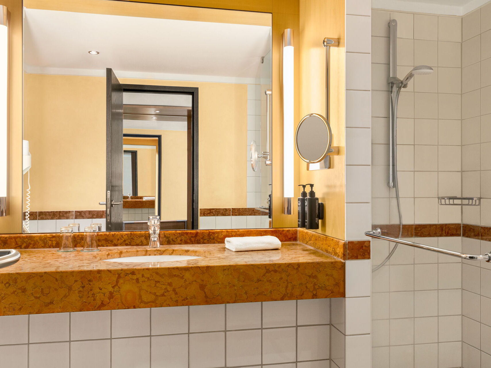 Hotel Remarque 2-Raum-Suite Badezimmer mit Waschbecken, Dusche, Spiegel