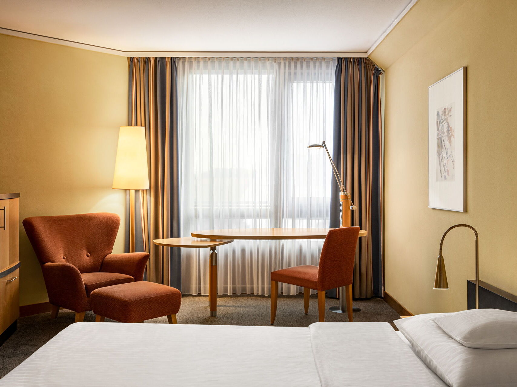 Executive double room with a double bed, nightstand, wardrobe, desk, armchair, and chair