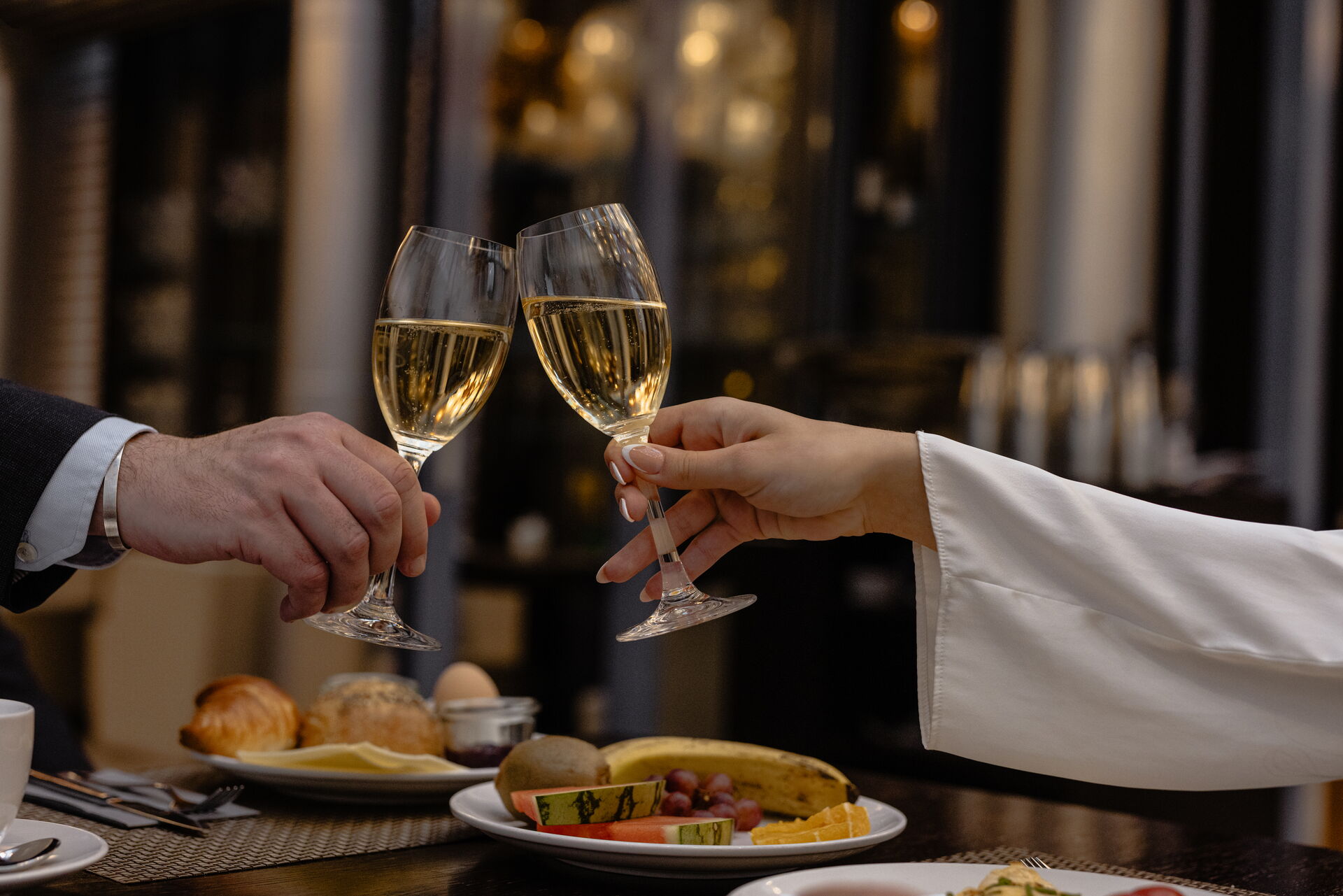 Zwei Weingläser, die einander an einem gemütlichen Restauranttisch zuprosten