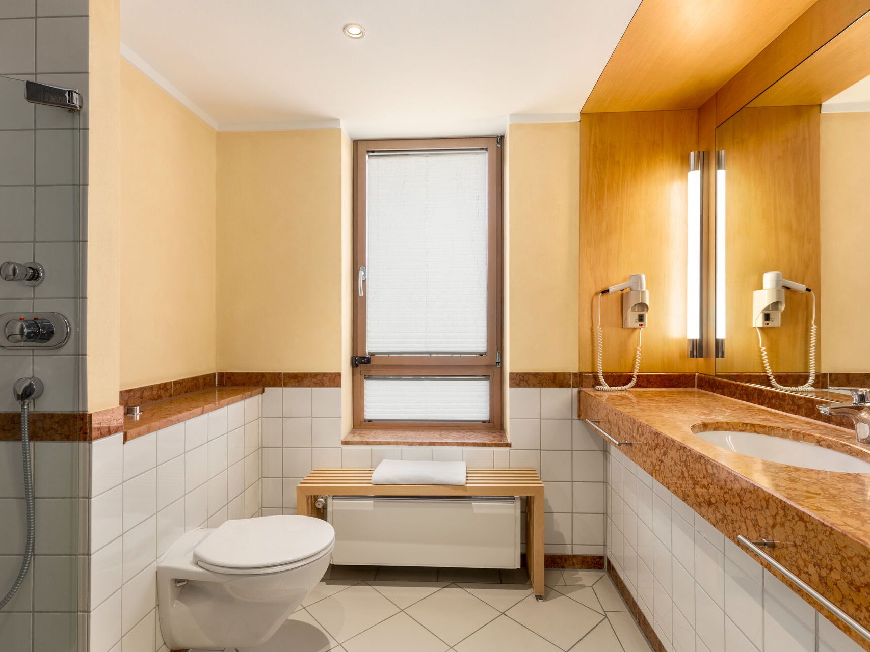Bad mit Dusche, Toilette, Waschbedecken, Spiegel und Fenster