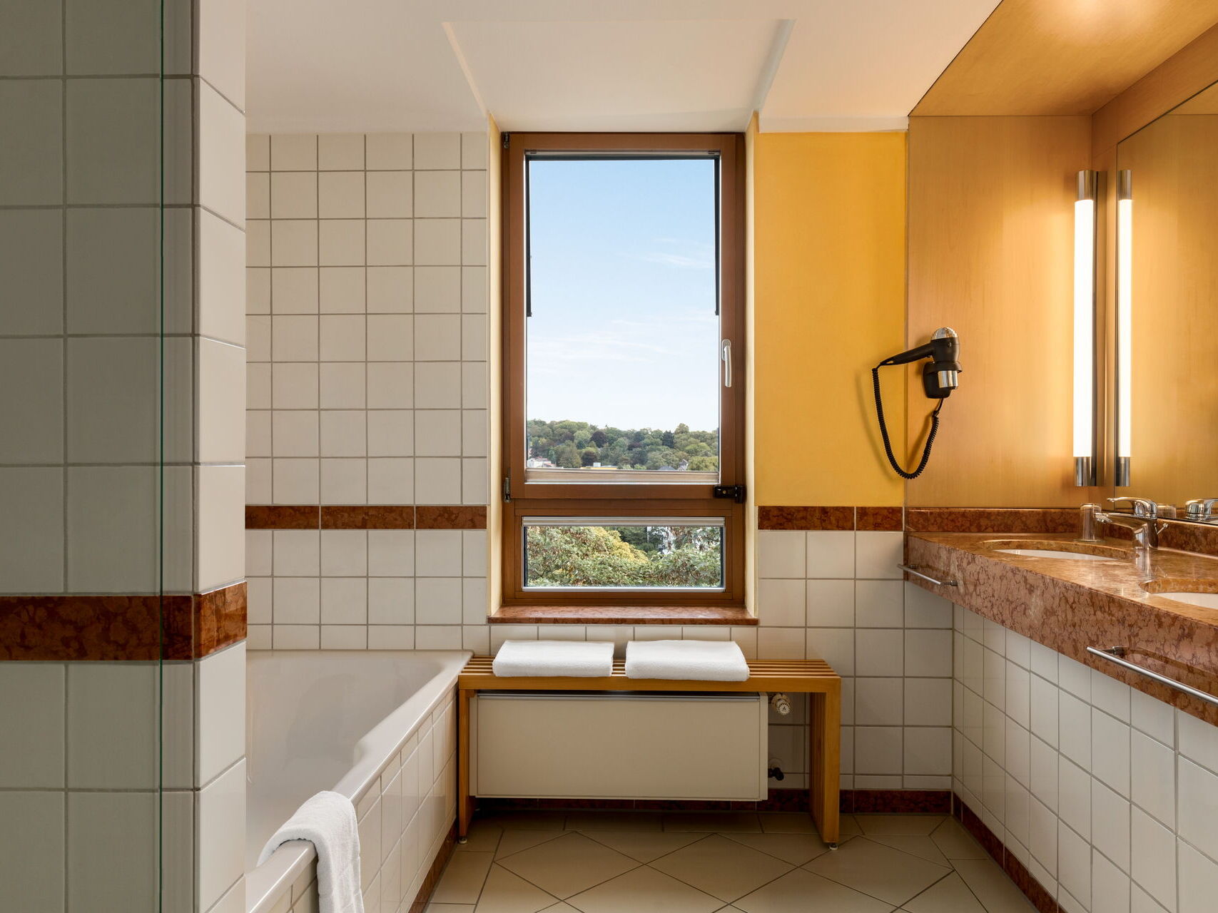 Hotel Remarque Panorama Suite Bad mit Badewanne, 2 Waschbedecken, Spiegel und Fenster