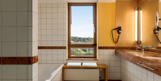 Hotel Remarque Panorama Suite Bad mit Badewanne, 2 Waschbedecken, Spiegel und Fenster